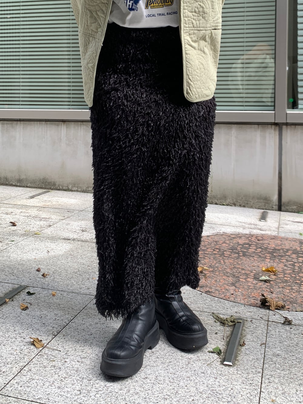 グリーン系のブルゾン、ホワイト系のTシャツ/カットソー、ブラック系のスカートを着用したレディースの秋コーディネートの4枚目の写真