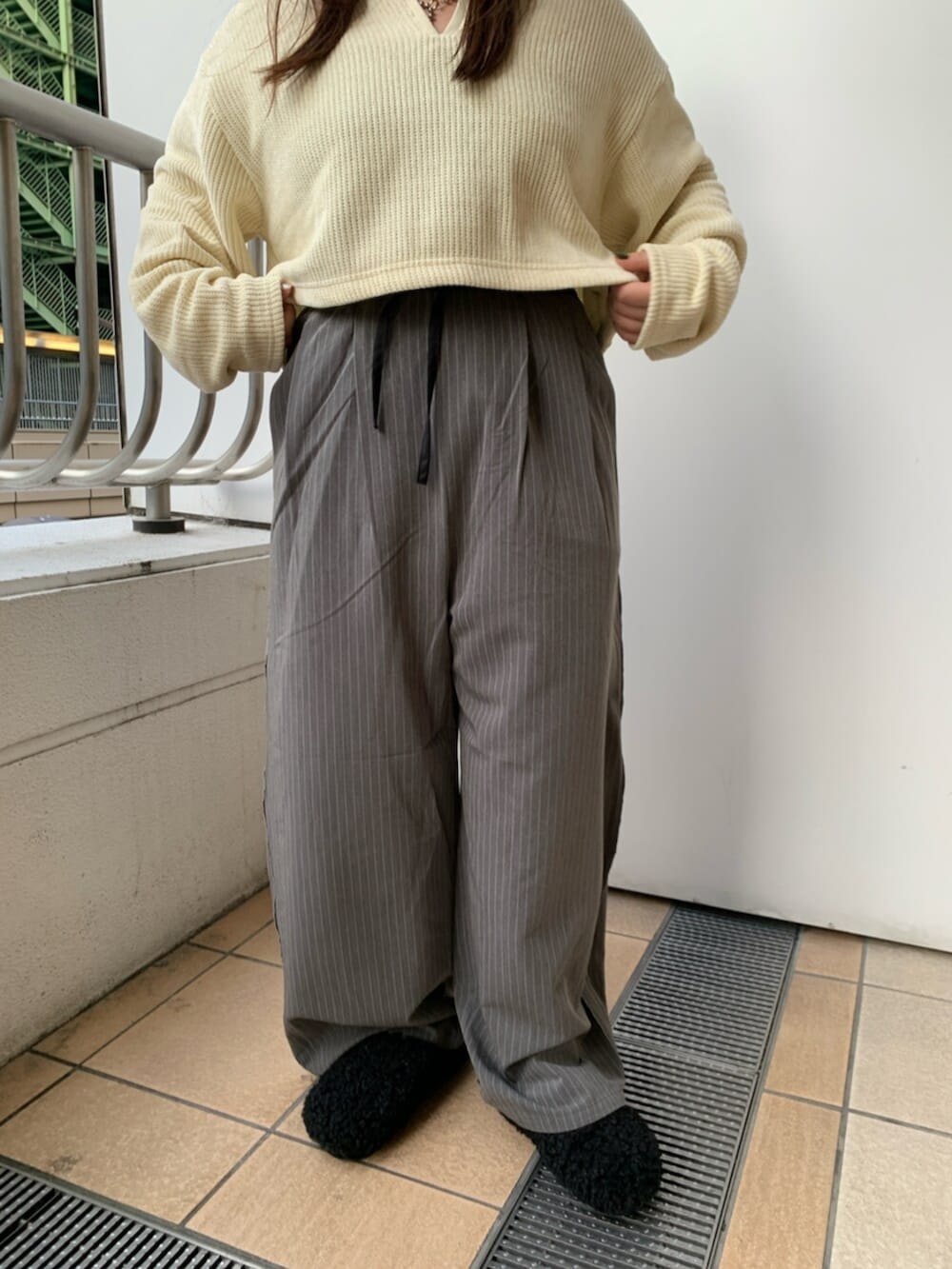 ブラック系のスリッポン、イエロー系のTシャツ/カットソー、グレー系のその他パンツを着用したレディースの冬コーディネートの5枚目の写真