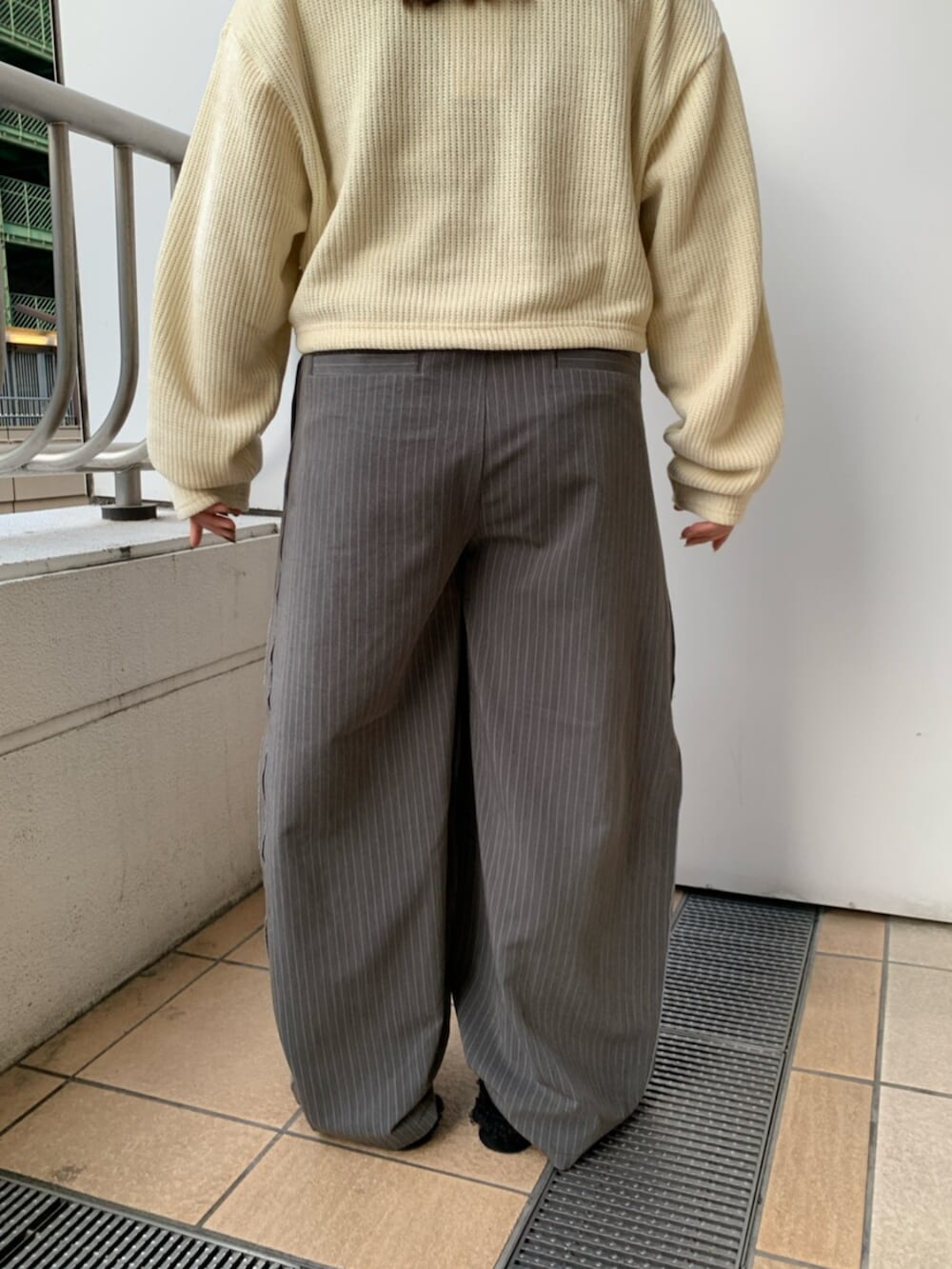 ブラック系のスリッポン、イエロー系のTシャツ/カットソー、グレー系のその他パンツを着用したレディースの冬コーディネートの7枚目の写真