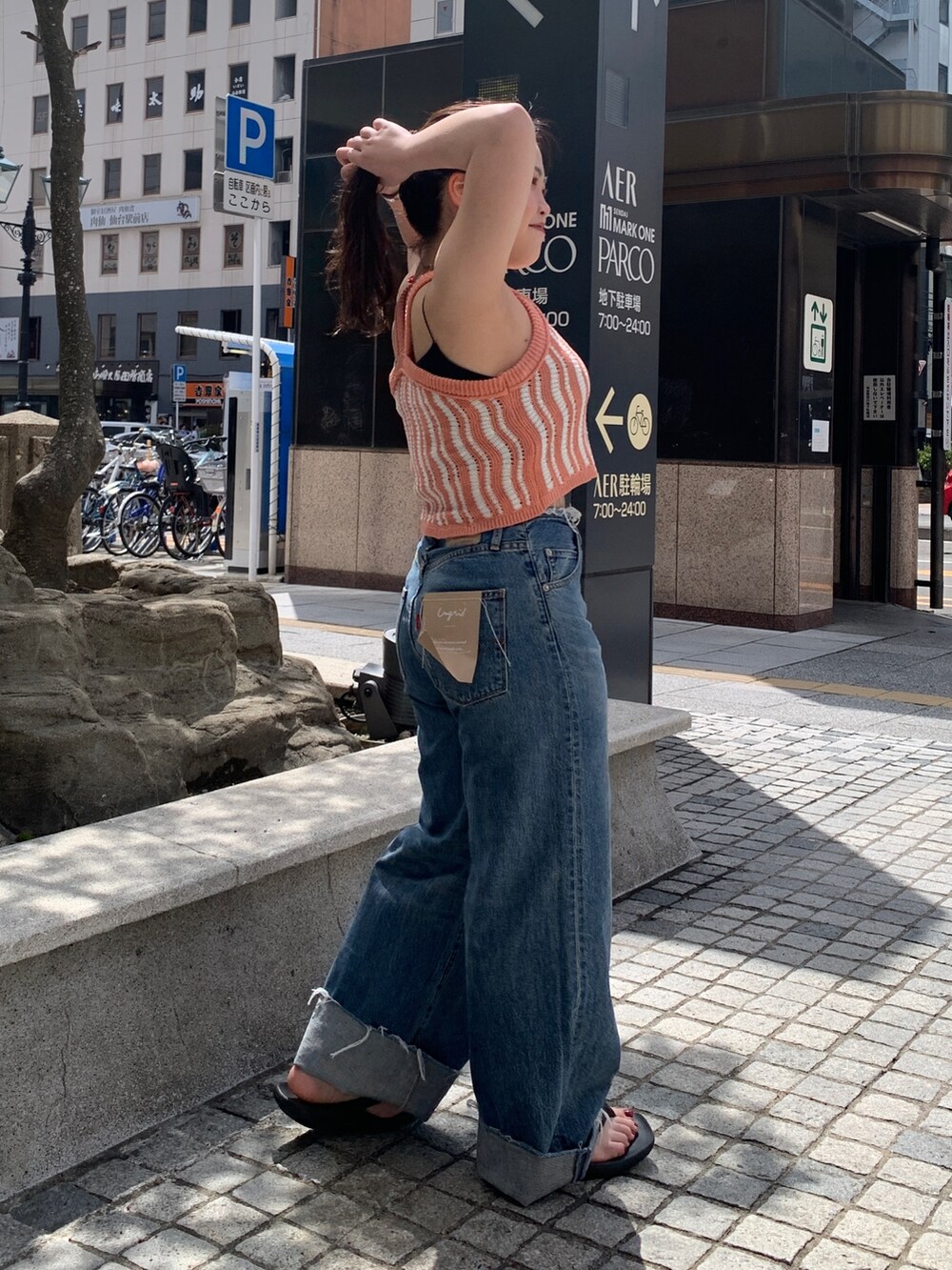 ブルー系のデニムパンツ、ピンク系のキャミソールを着用したレディースの春コーディネートの2枚目の写真