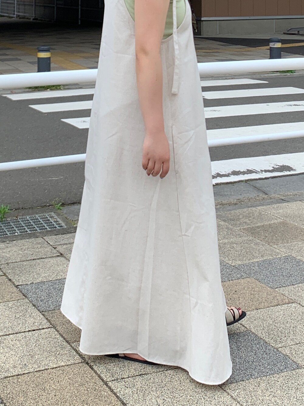 ホワイト系のワンピース、グリーン系のタンクトップを着用したレディースの春コーディネートの6枚目の写真