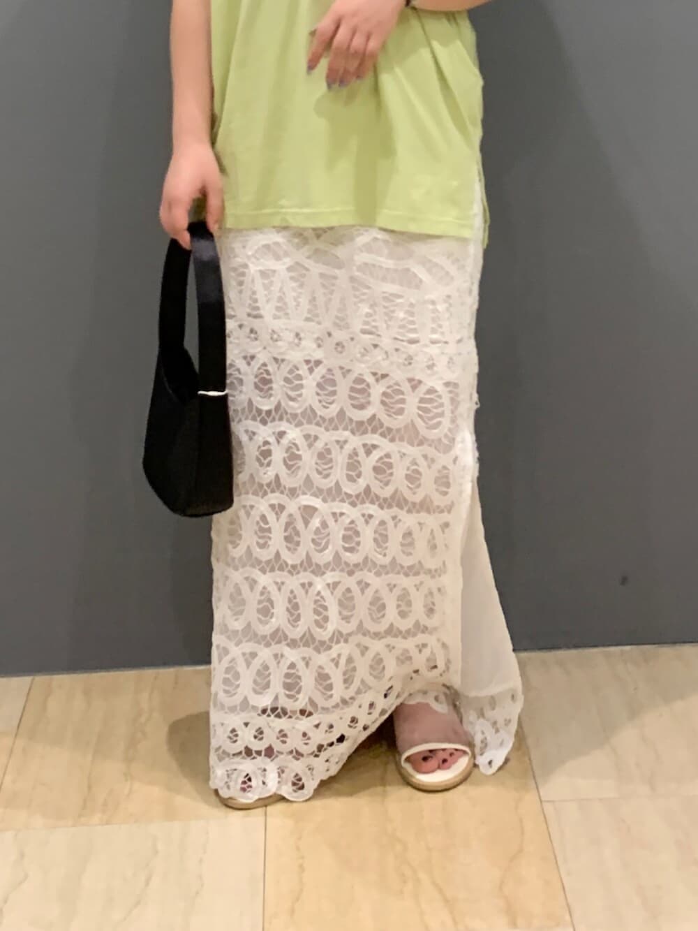 グリーン系のタンクトップ、ホワイト系のスカートを着用したレディースの夏コーディネートの5枚目の写真