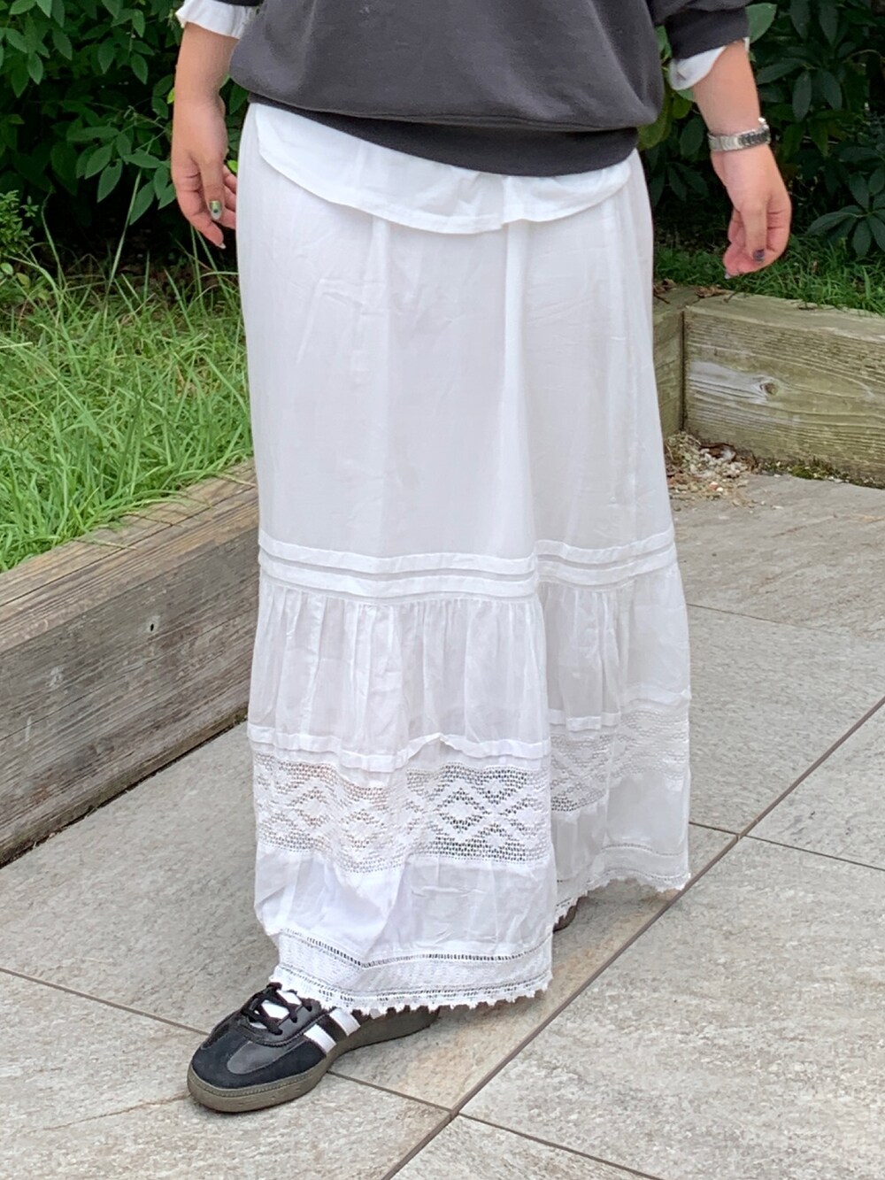 グレー系のスウェット、ホワイト系のTシャツ/カットソー、ホワイト系のスカートを着用したレディースの秋コーディネートの5枚目の写真