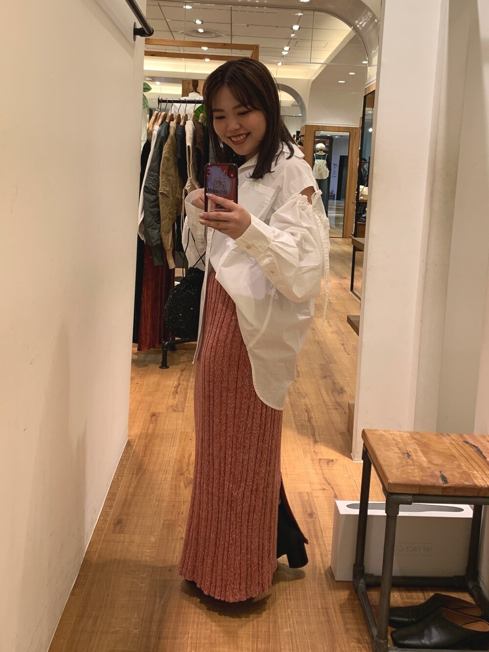 ホワイト系のシャツ/ブラウス、ブラック系のハンドバッグ、レッド系のスカートを着用したレディースの秋コーディネートの2枚目の写真