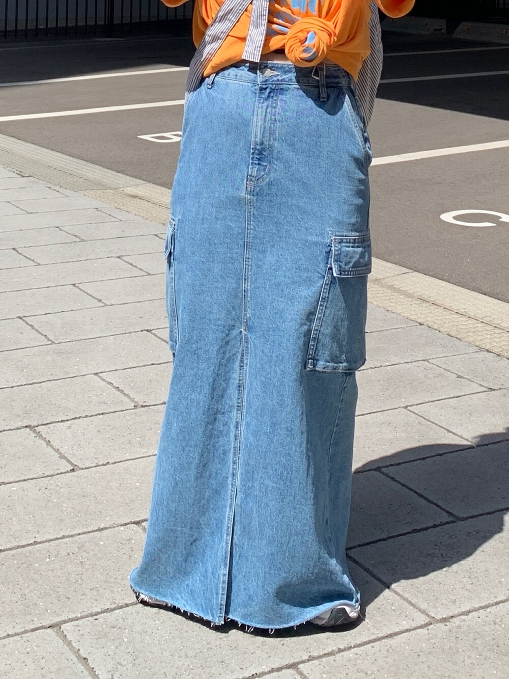 オレンジ系のTシャツ/カットソー、その他のショルダーバッグ、ブルー系のデニムスカートを着用したレディースの春コーディネートの5枚目の写真