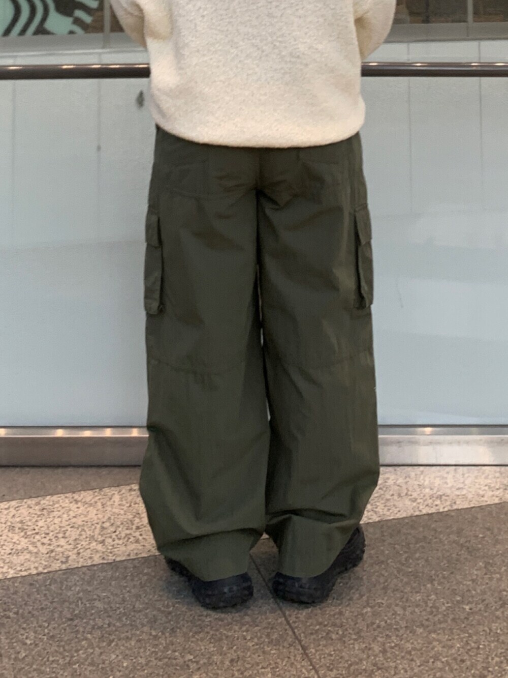 ホワイト系のニット/セーター、グリーン系のその他パンツを着用したレディースの冬コーディネートの7枚目の写真