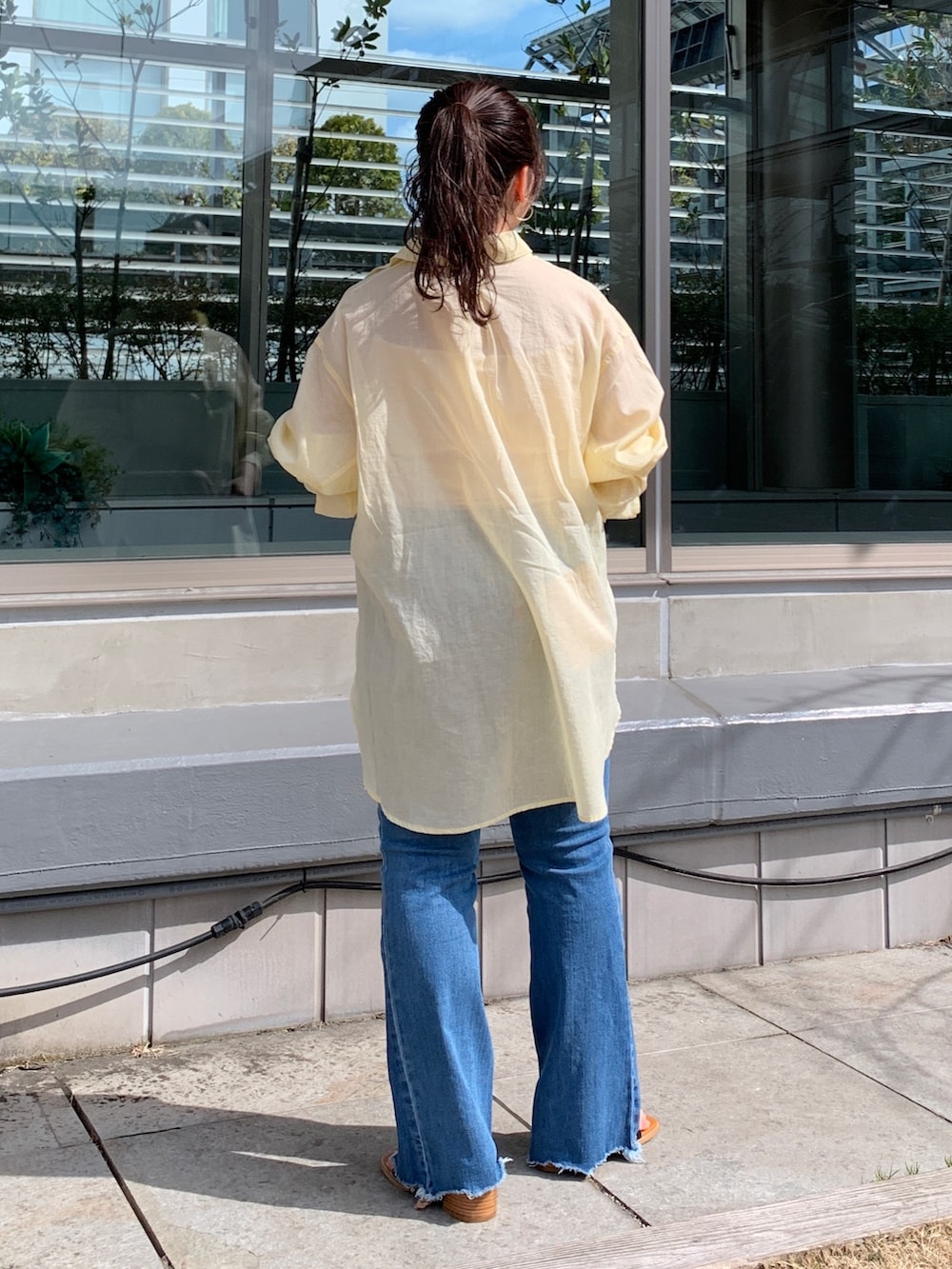 イエロー系のシャツ/ブラウス、ブルー系のデニムパンツ、ブラック系のサンダルを着用したレディースの春コーディネートの3枚目の写真