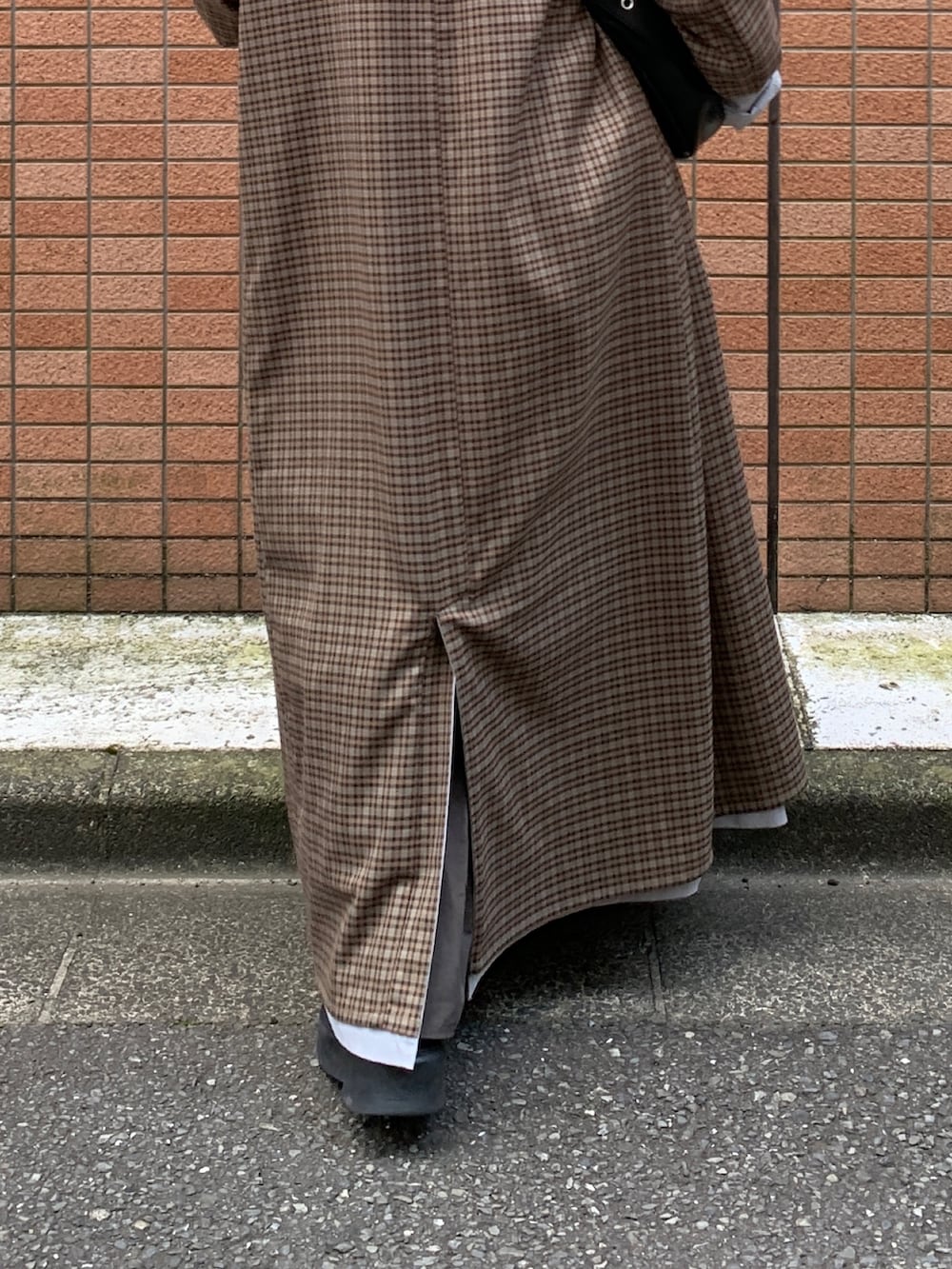 グレー系のスカート、ブルー系のステンカラーコートを着用したレディースの秋コーディネートの7枚目の写真