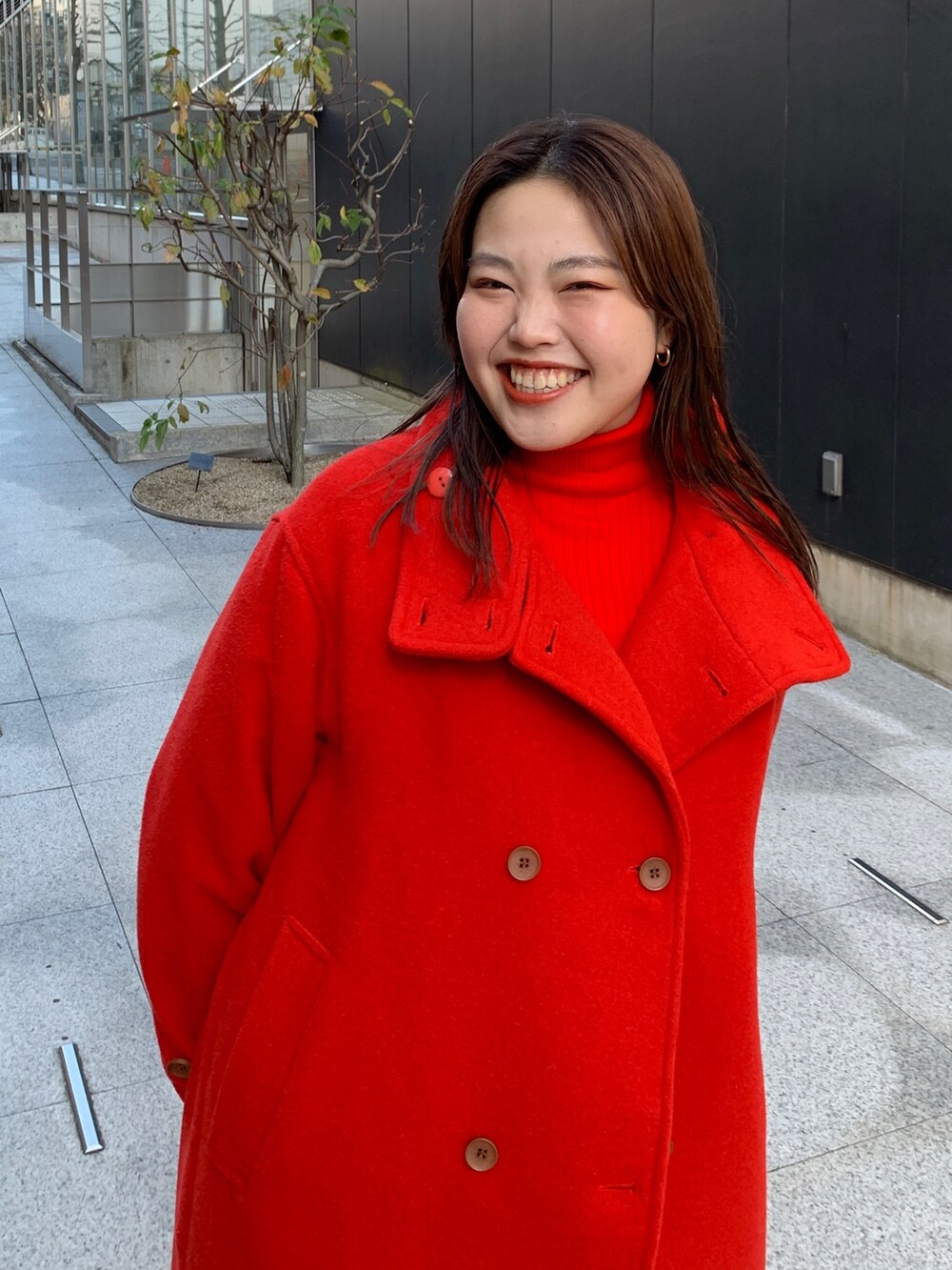 レッド系のその他アウター、ブルー系のデニムパンツを着用したレディースの冬コーディネートの6枚目の写真