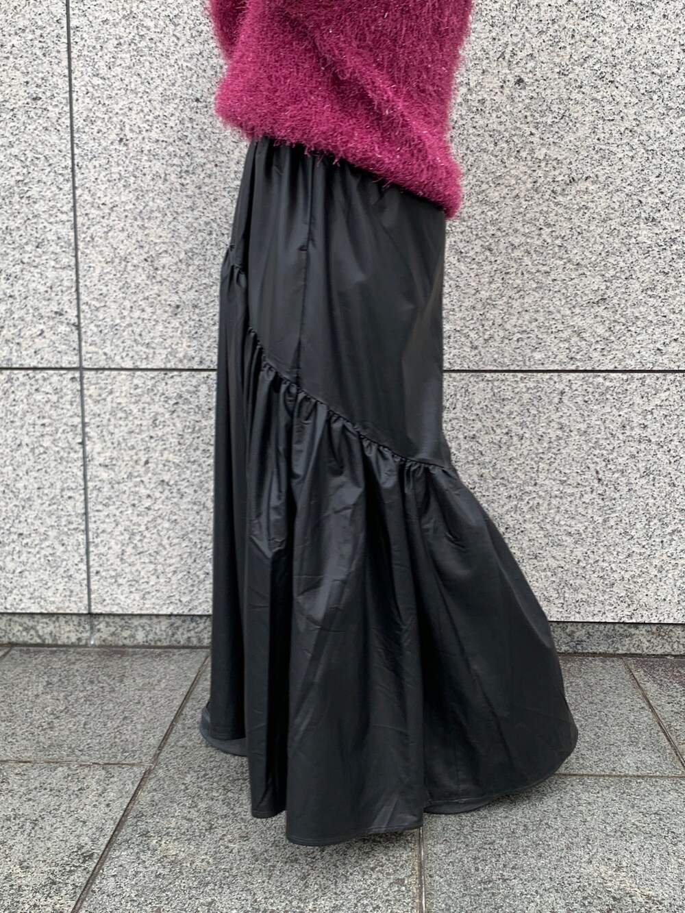 パープル系のニット/セーター、ブラック系のスカート、ブラック系のブーツを着用したレディースの秋コーディネートの6枚目の写真