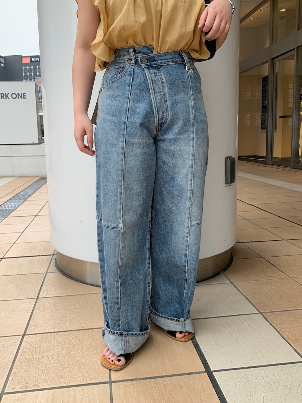 イエロー系のシャツ/ブラウス、ブルー系のデニムパンツを着用したレディースの夏コーディネートの5枚目の写真