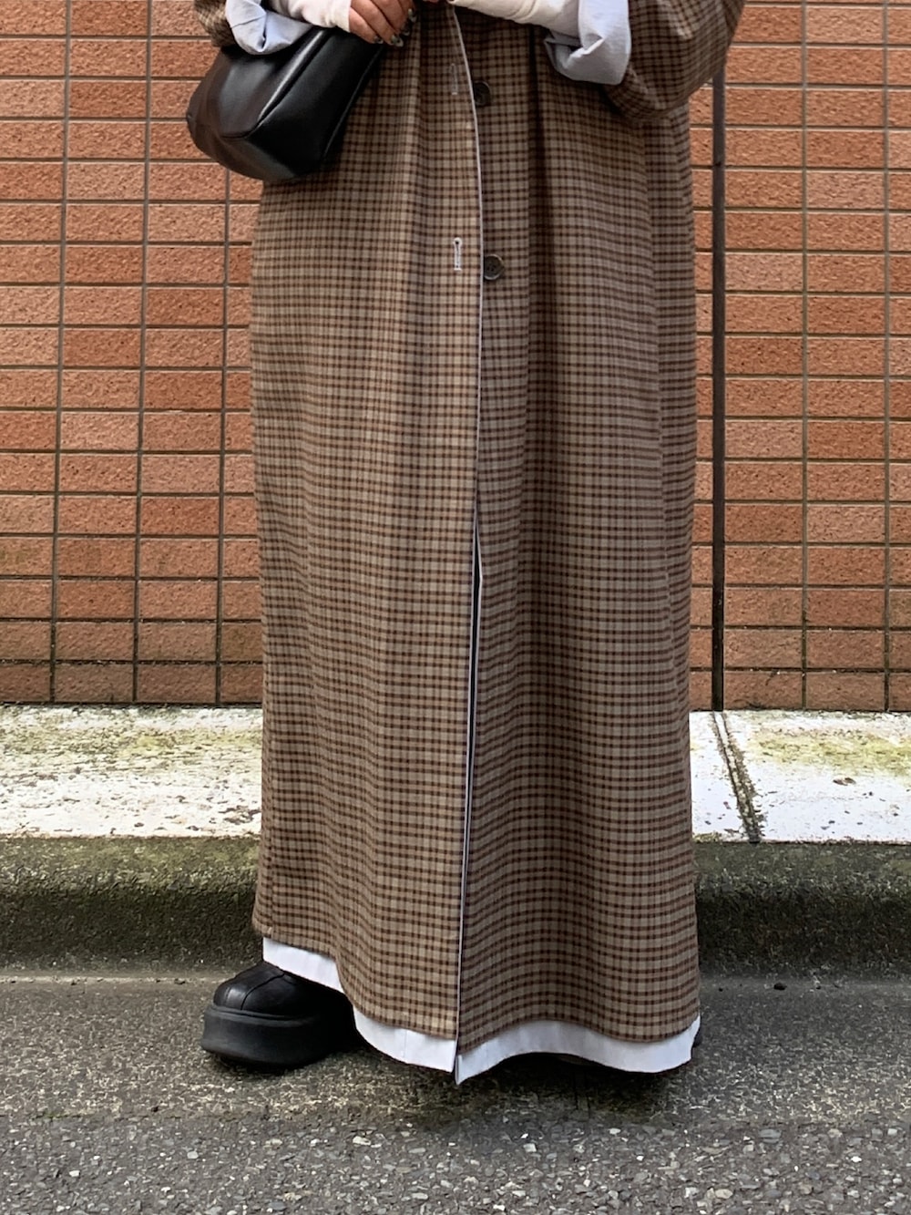 グレー系のスカート、ブルー系のステンカラーコートを着用したレディースの秋コーディネートの5枚目の写真