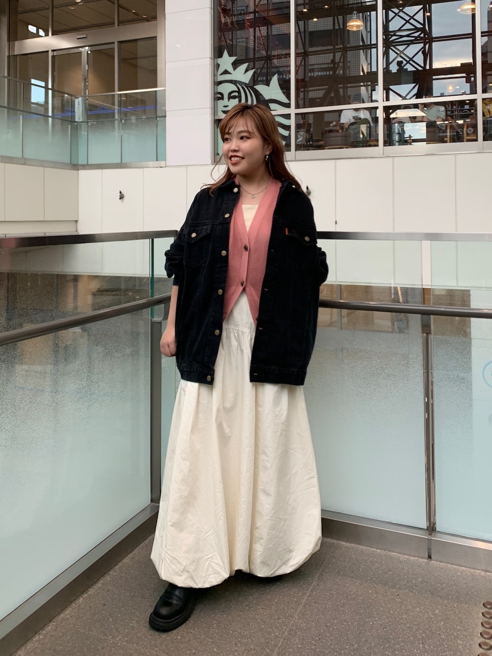 ブラック系のデニムジャケット、ピンク系のベスト、ホワイト系のキャミソールを着用したレディースの夏コーディネートの2枚目の写真