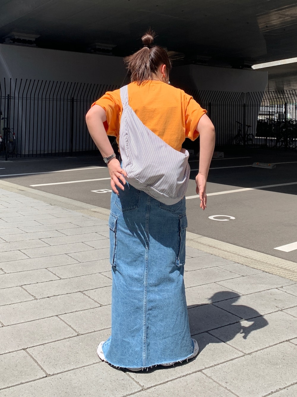 オレンジ系のTシャツ/カットソー、その他のショルダーバッグ、ブルー系のデニムスカートを着用したレディースの春コーディネートの3枚目の写真