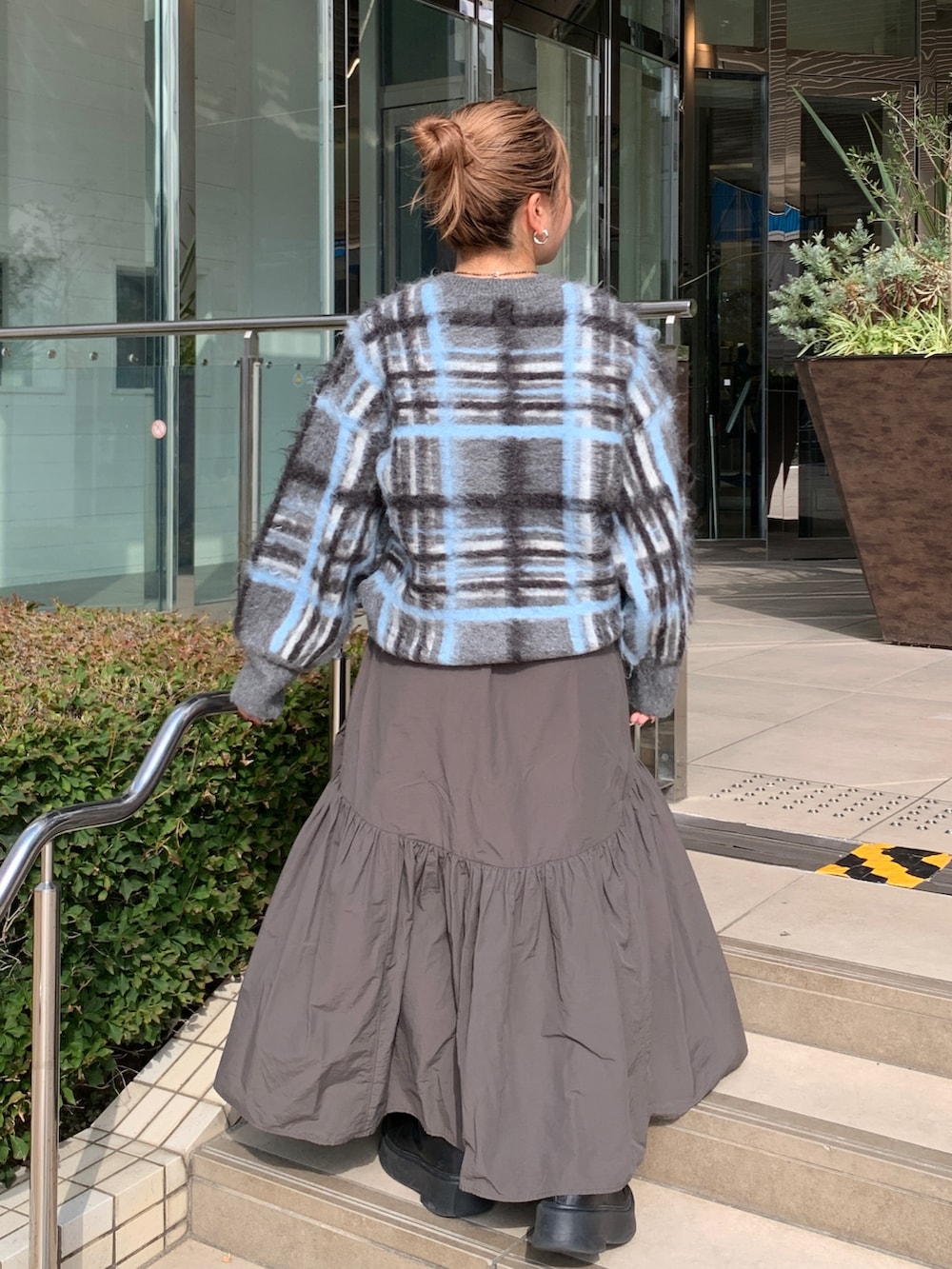 グレー系のニット/セーター、グレー系のスカートを着用したレディースの秋コーディネートの3枚目の写真