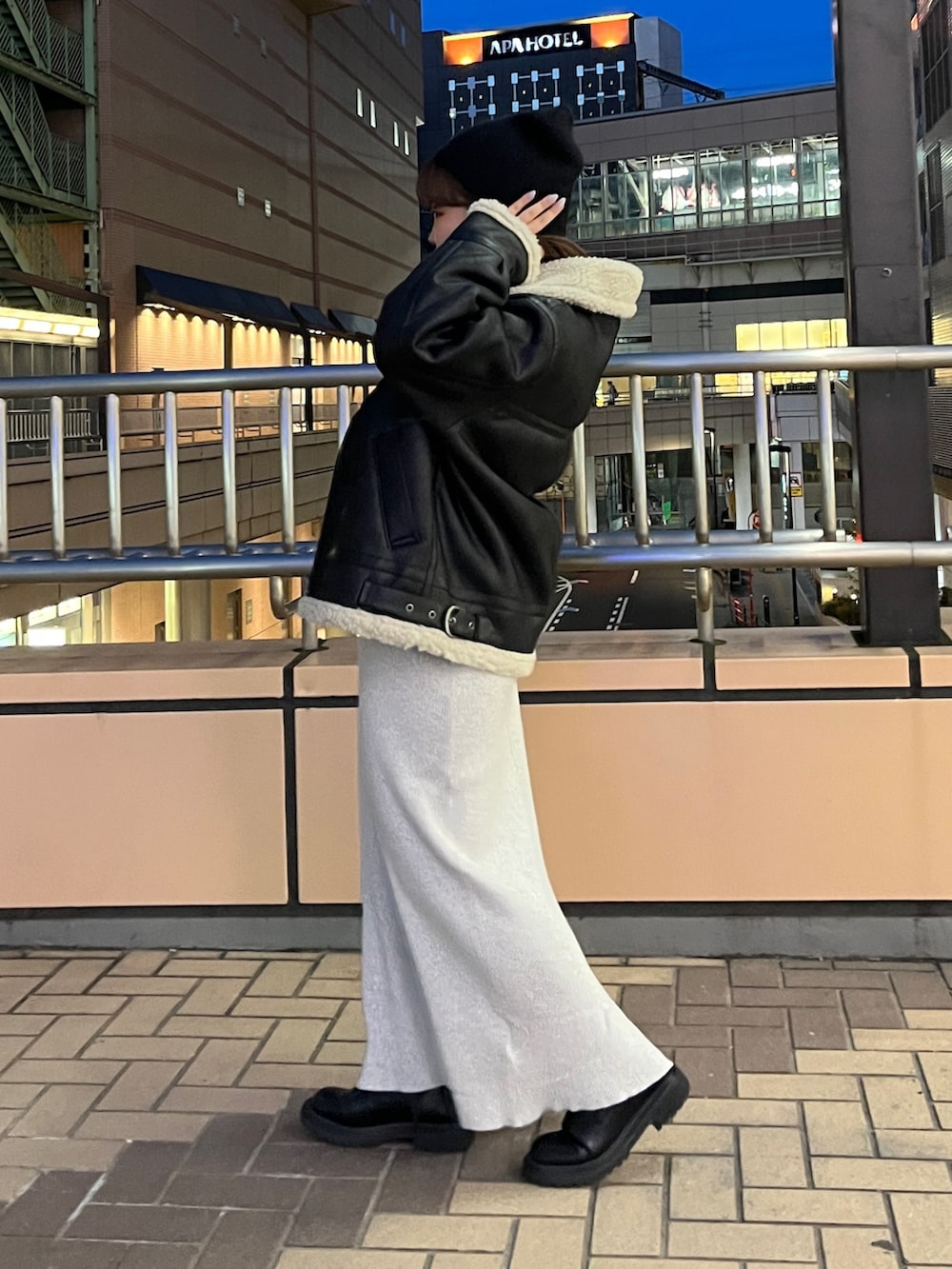 グレー系のワンピース、ブラック系のムートンコート、ブラック系のニットキャップ/ビーニーを着用したレディースの秋コーディネートの3枚目の写真