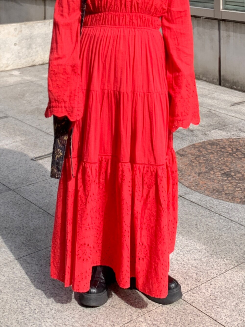 レッド系のワンピース、ブラック系のショルダーバッグ、レッド系のネックレスを着用したレディースの冬コーディネートの5枚目の写真