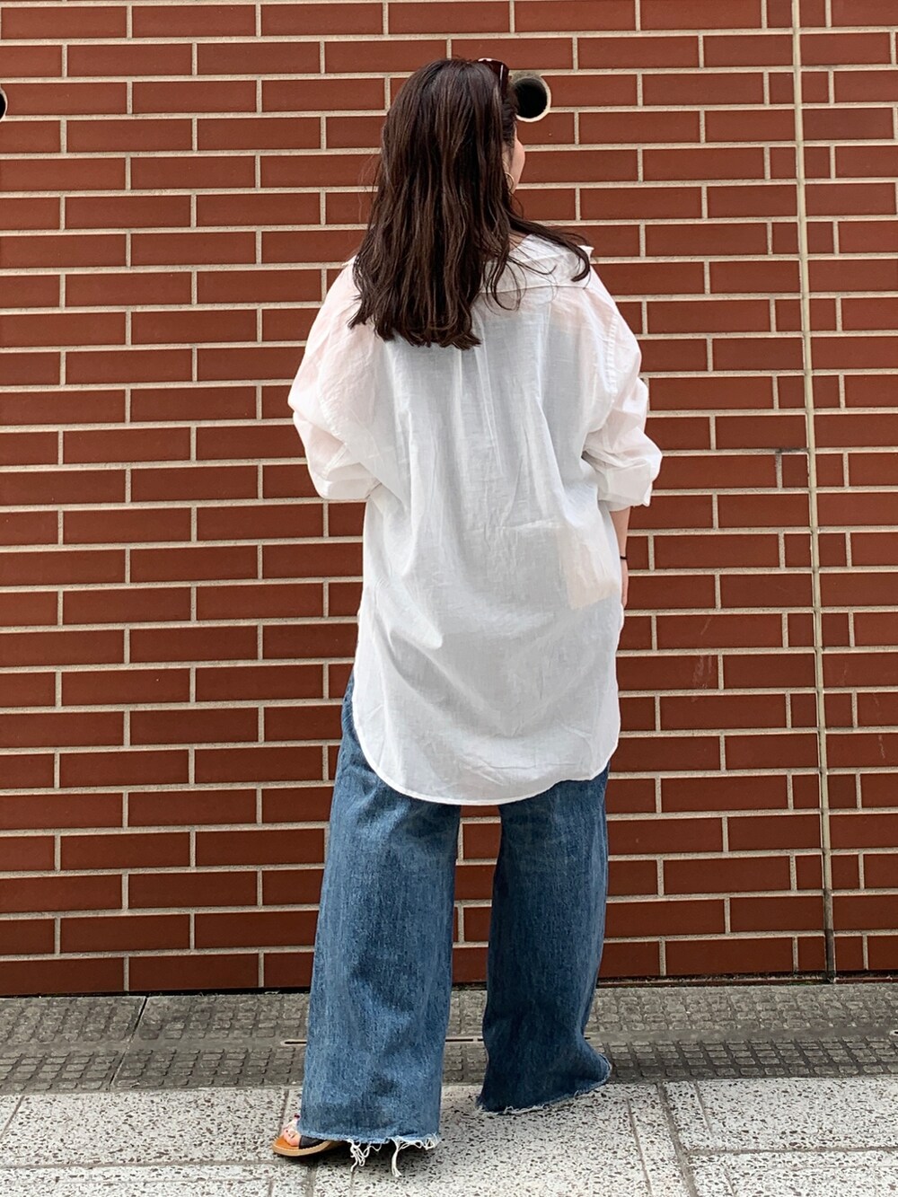 ブルー系のキャミソール、ホワイト系のシャツ/ブラウス、ブルー系のデニムパンツを着用したレディースの春コーディネートの3枚目の写真