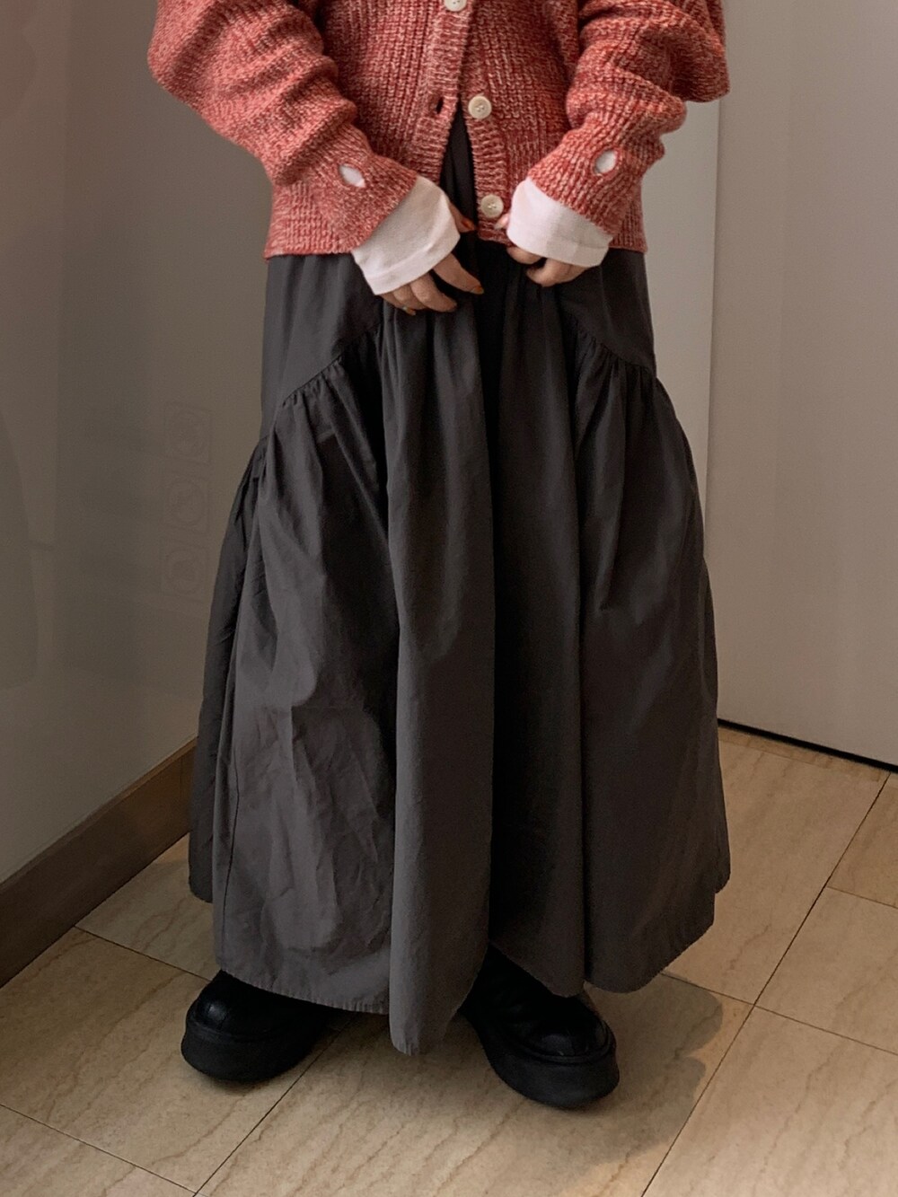 ピンク系のTシャツ/カットソー、オレンジ系のカーディガン/ボレロ、グレー系のスカートを着用したレディースの冬コーディネートの5枚目の写真