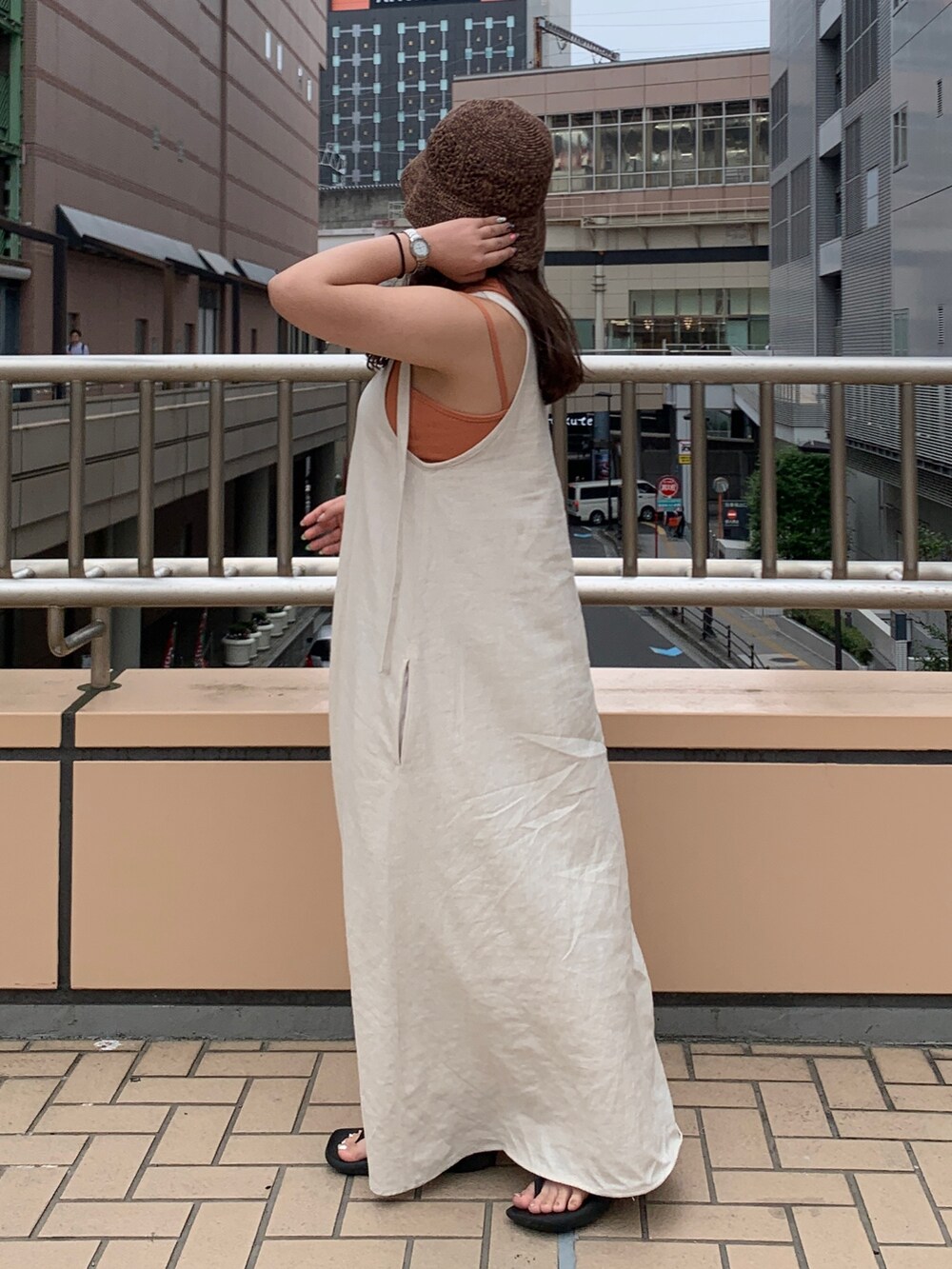 ホワイト系のワンピース、ブラウン系のニットキャップ/ビーニーを着用したレディースの夏コーディネートの2枚目の写真