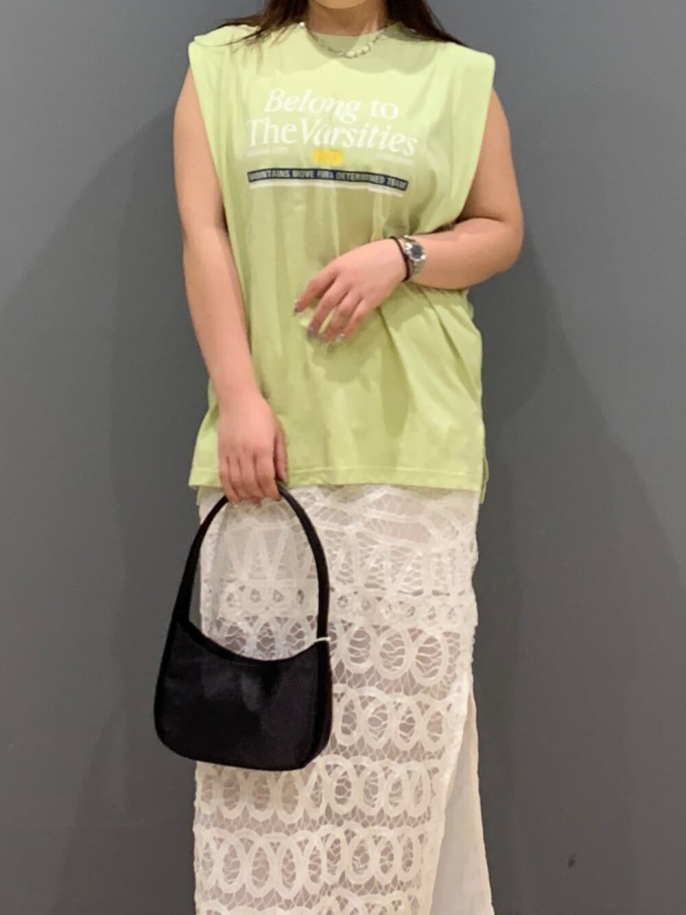 グリーン系のタンクトップ、ホワイト系のスカートを着用したレディースの夏コーディネートの4枚目の写真