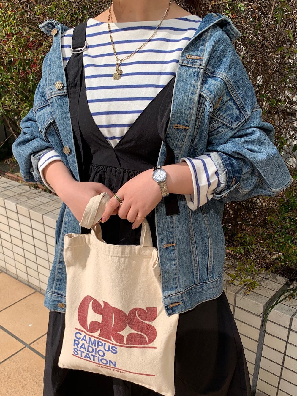 ホワイト系のTシャツ/カットソー、ブルー系のデニムジャケット、ブラック系のワンピースを着用したレディースの春コーディネートの8枚目の写真