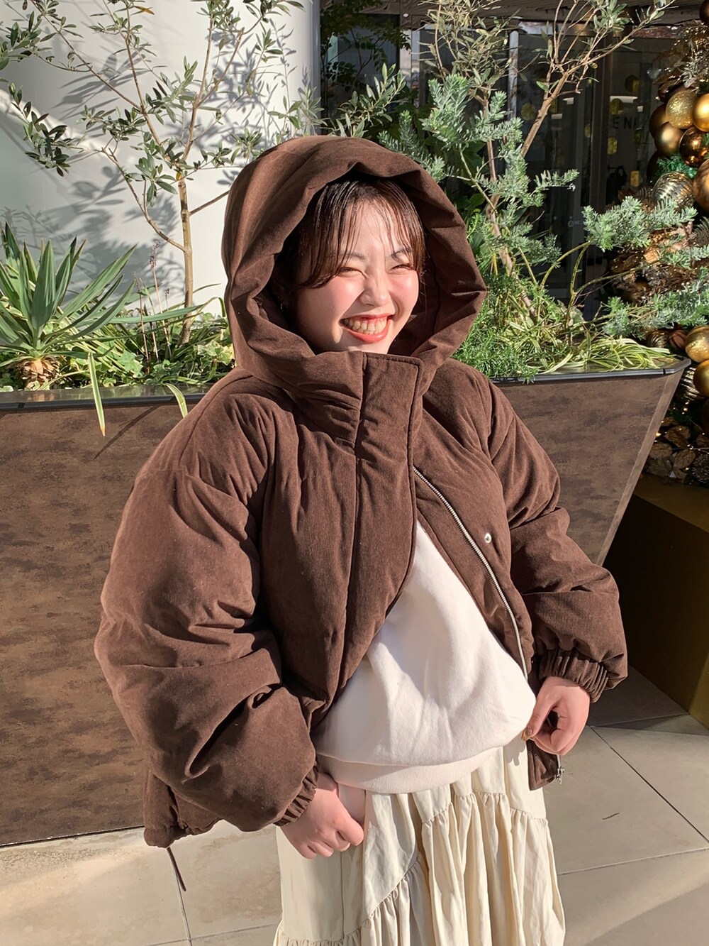 ホワイト系のスウェット、ブラウン系のブルゾン、ホワイト系のスカートを着用したレディースの冬コーディネートの4枚目の写真