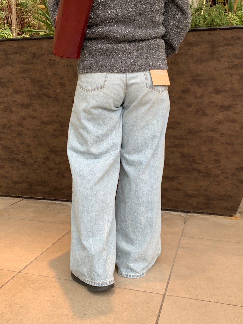 ブラック系のニット/セーター、ブルー系のデニムパンツを着用したレディースの冬コーディネートの6枚目の写真