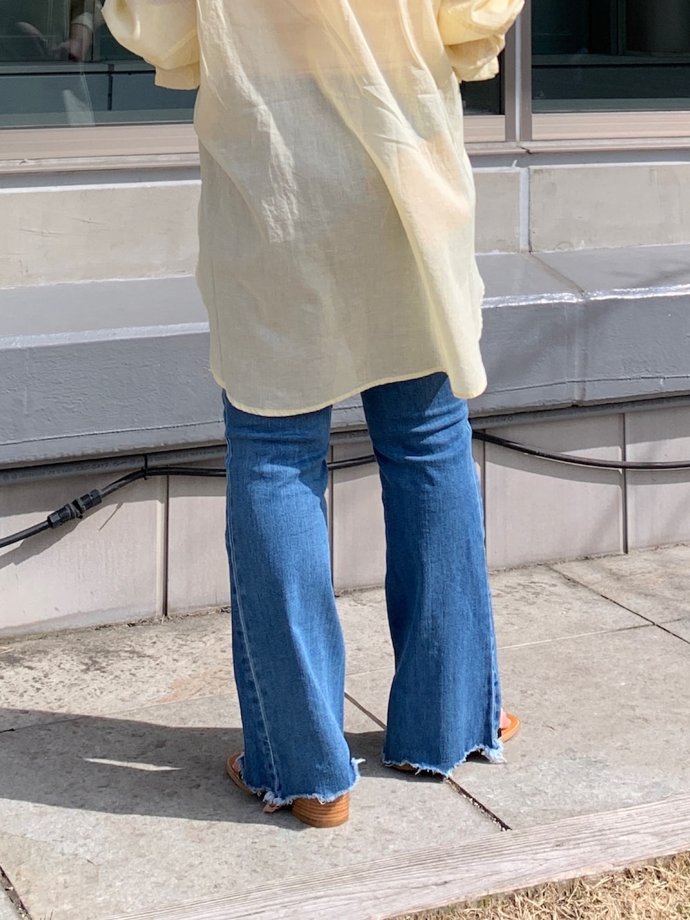 イエロー系のシャツ/ブラウス、ブルー系のデニムパンツ、ブラック系のサンダルを着用したレディースの春コーディネートの6枚目の写真