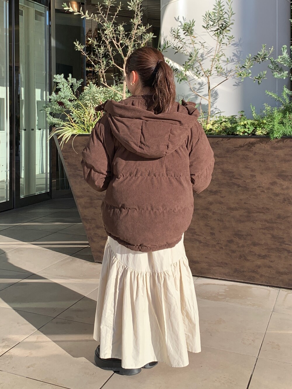 ホワイト系のスウェット、ブラウン系のブルゾン、ホワイト系のスカートを着用したレディースの冬コーディネートの3枚目の写真