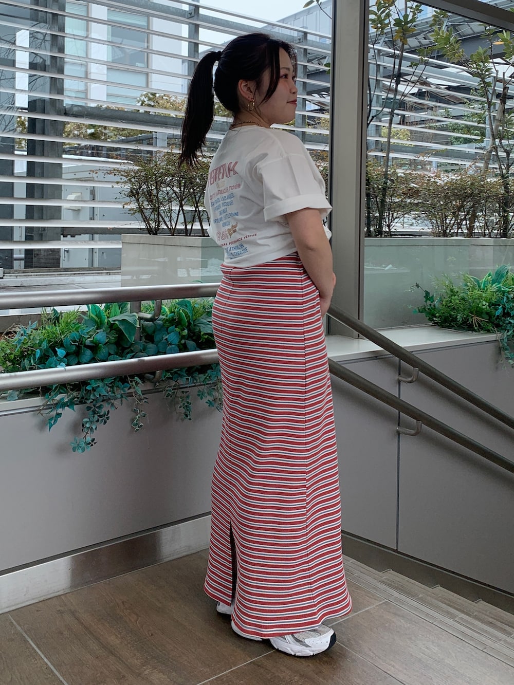 レッド系のワンピース、ホワイト系のTシャツ/カットソーを着用したレディースの春コーディネートの2枚目の写真