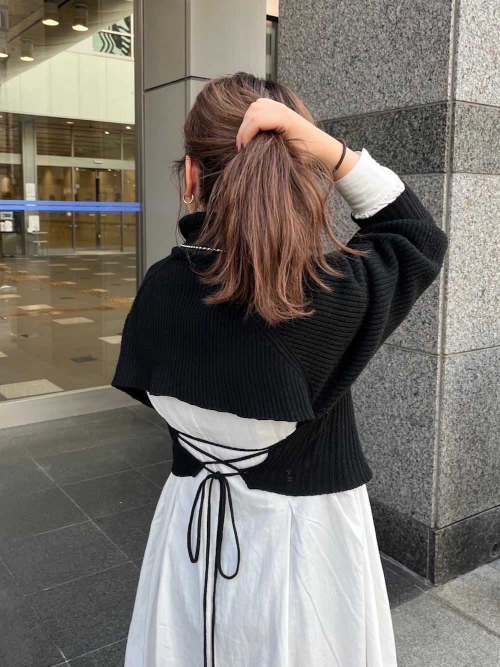 ブラウン系のムートンコート、ブラック系のワンピースを着用したレディースの秋コーディネートの8枚目の写真