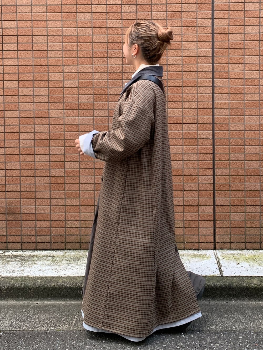 グレー系のスカート、ブルー系のステンカラーコートを着用したレディースの秋コーディネートの2枚目の写真