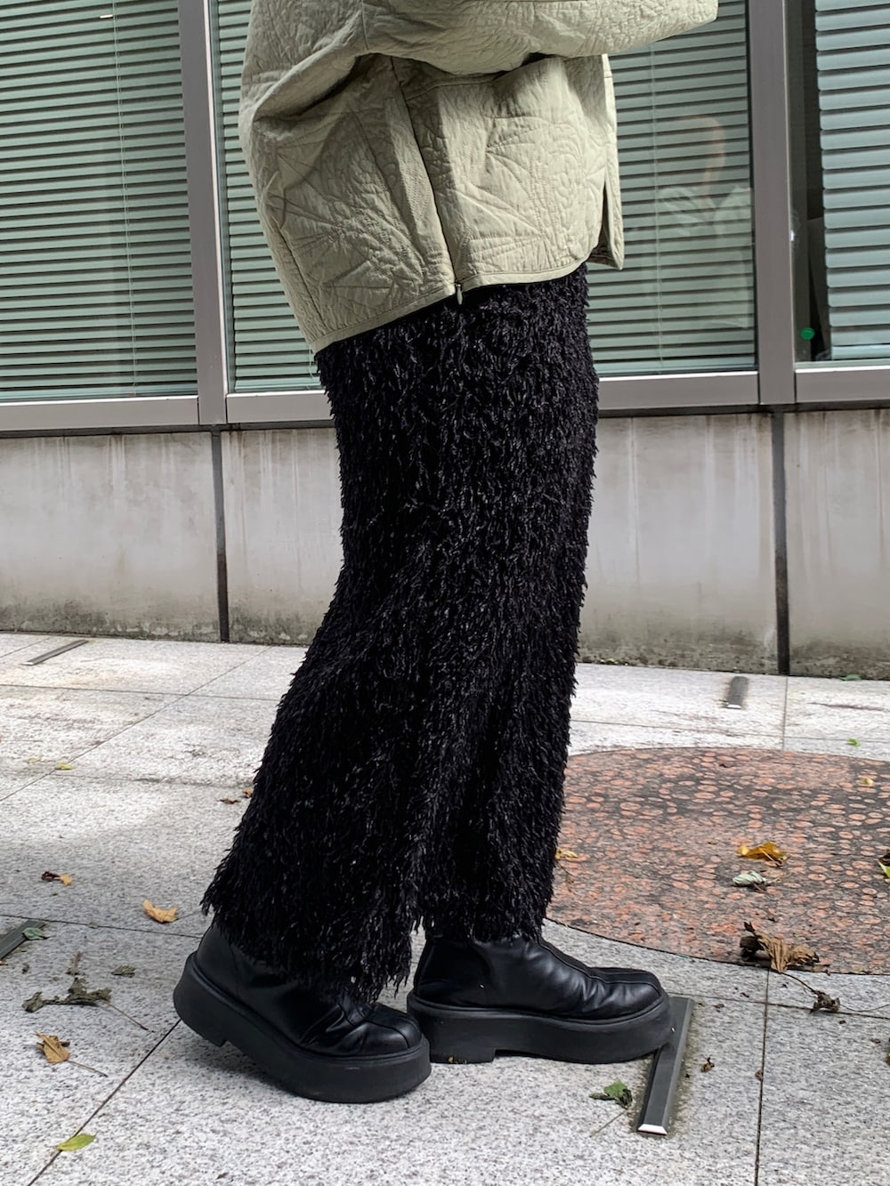 グリーン系のブルゾン、ホワイト系のTシャツ/カットソー、ブラック系のスカートを着用したレディースの秋コーディネートの5枚目の写真