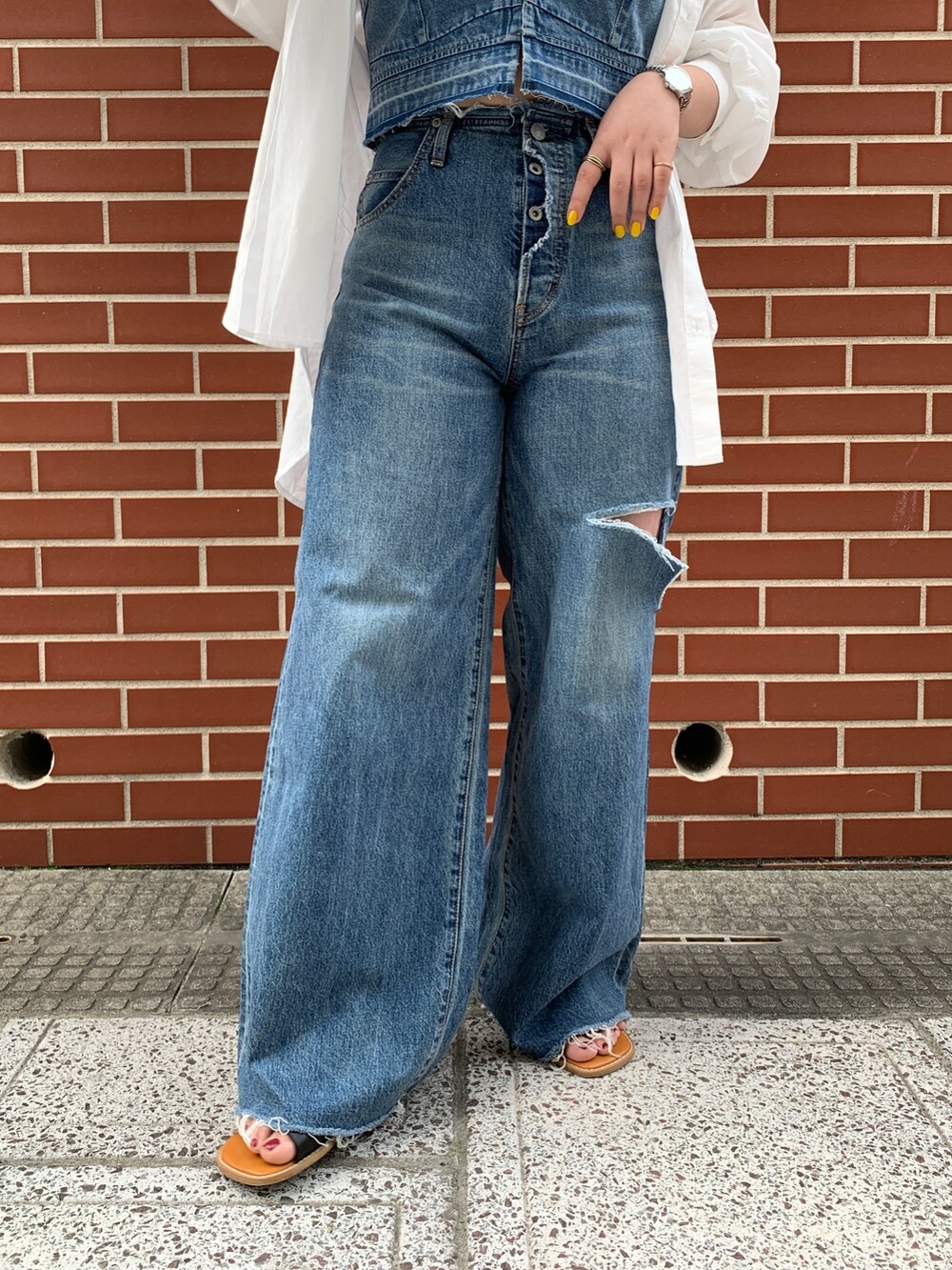 ブルー系のキャミソール、ホワイト系のシャツ/ブラウス、ブルー系のデニムパンツを着用したレディースの春コーディネートの6枚目の写真