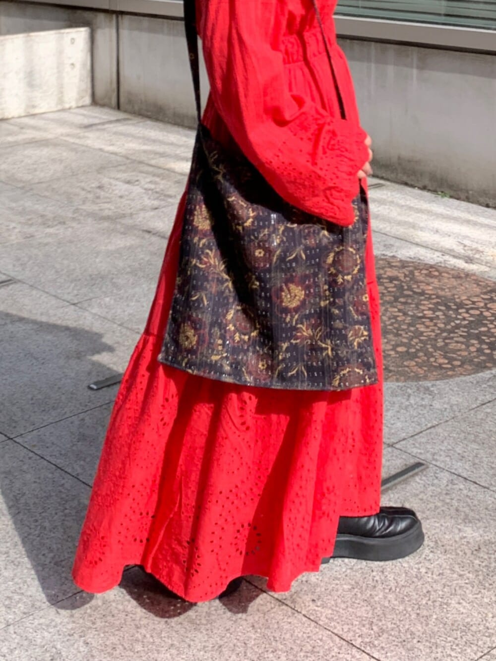 レッド系のワンピース、ブラック系のショルダーバッグ、レッド系のネックレスを着用したレディースの冬コーディネートの6枚目の写真