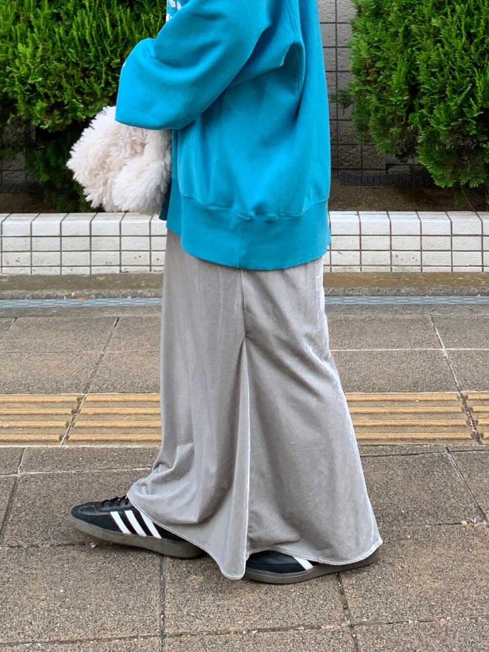 ブルー系のスウェット、ホワイト系のハンドバッグ、グレー系のスカートを着用したレディースの秋コーディネートの6枚目の写真