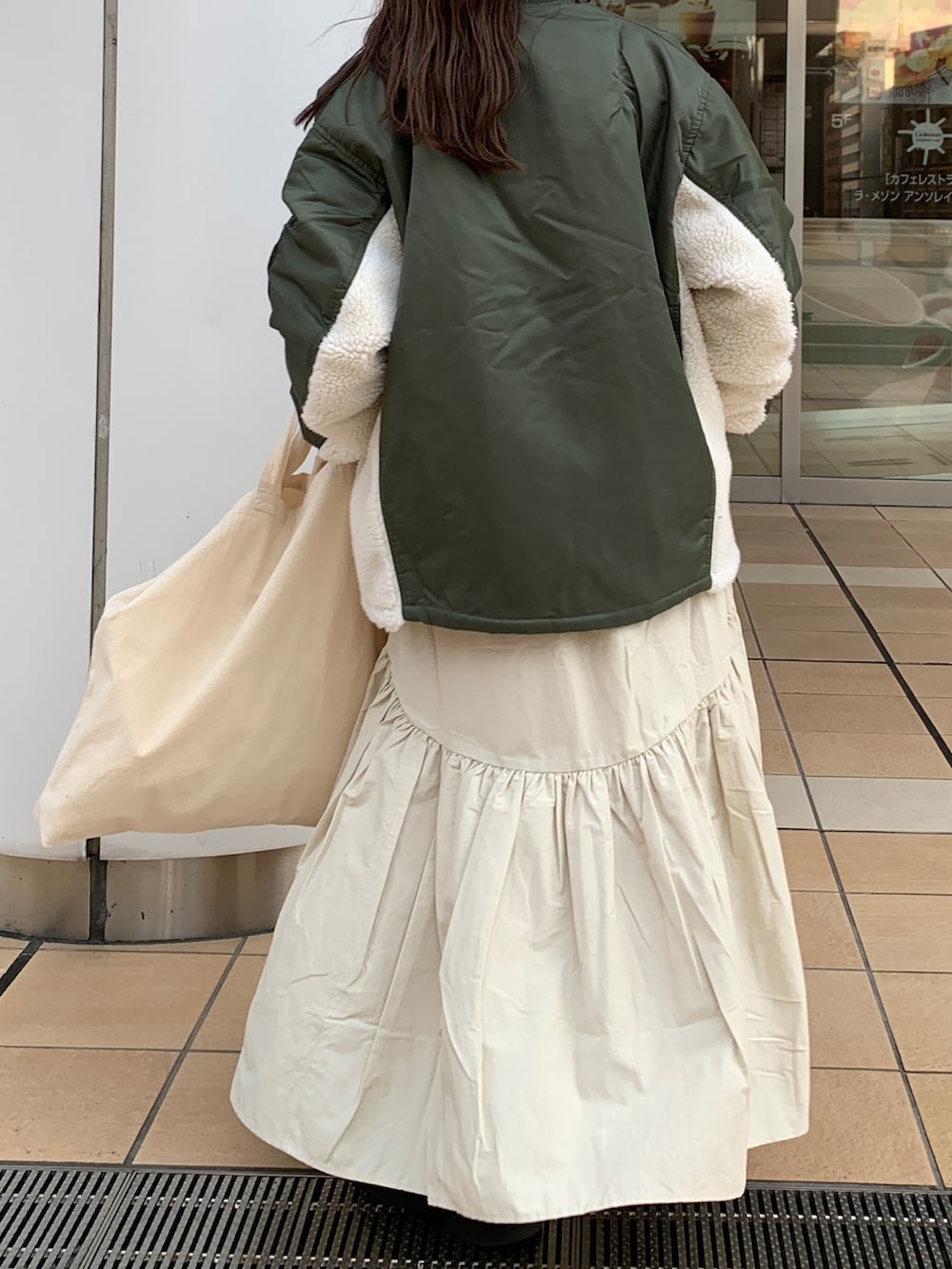 ホワイト系のスカート、ホワイト系のニット/セーター、グリーン系のMA-1を着用したレディースの冬コーディネートの7枚目の写真