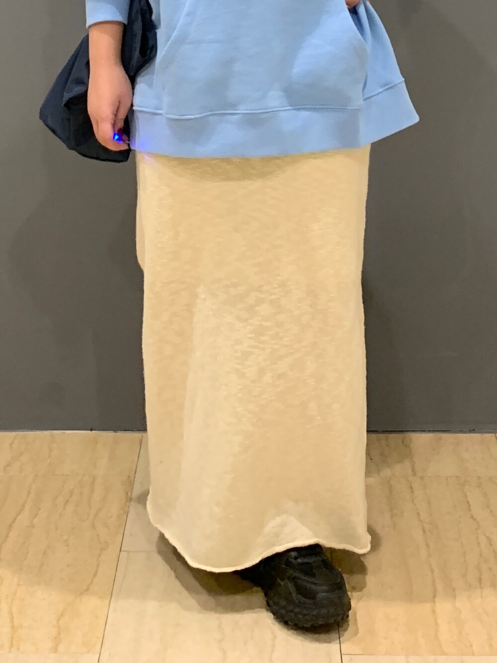 ブルー系のパーカー、ホワイト系のスカート、ブルー系のトートバッグを着用したレディースの冬コーディネートの5枚目の写真