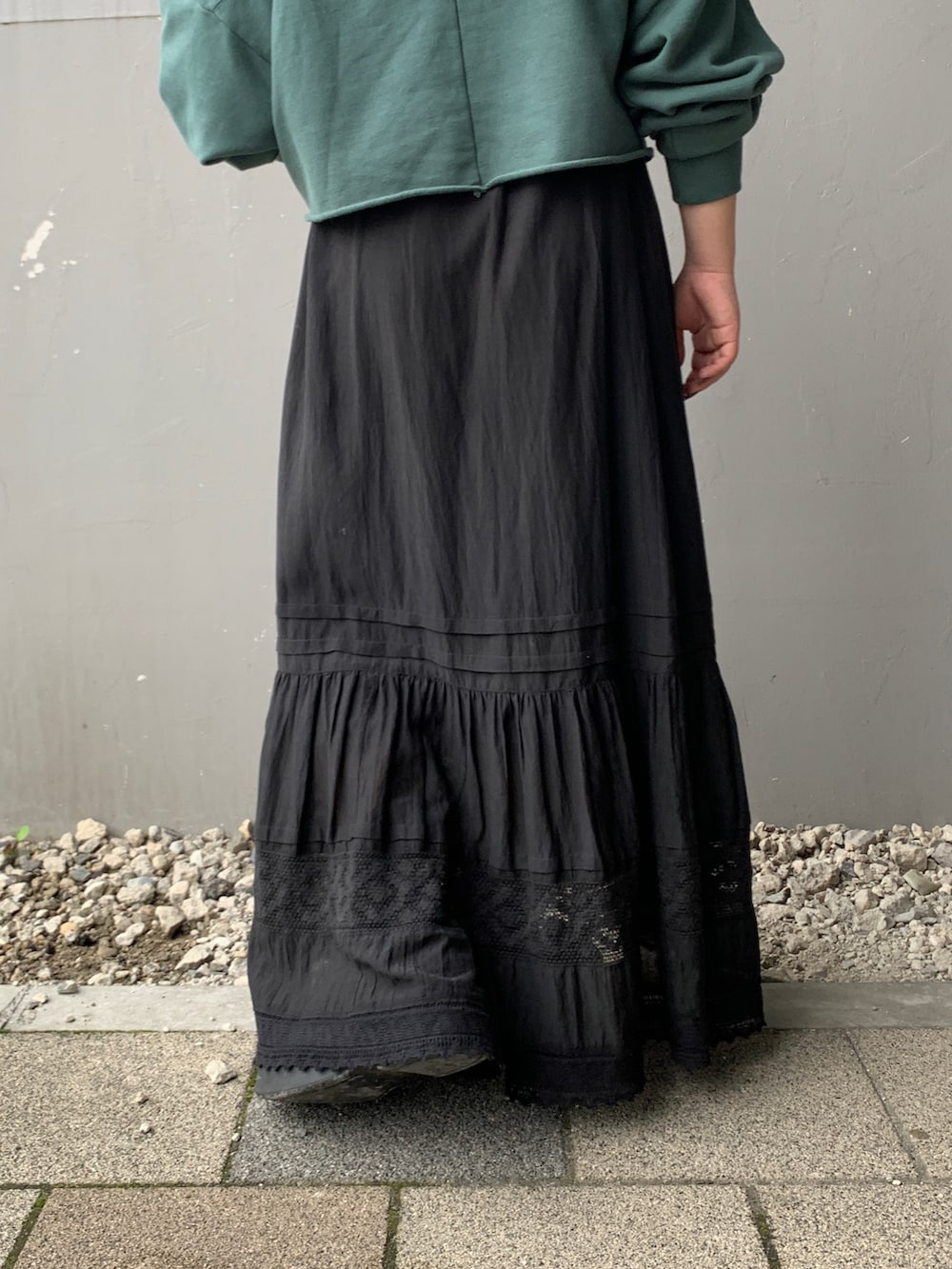 グリーン系のパーカー、ブラック系のスカートを着用したレディースの夏コーディネートの7枚目の写真