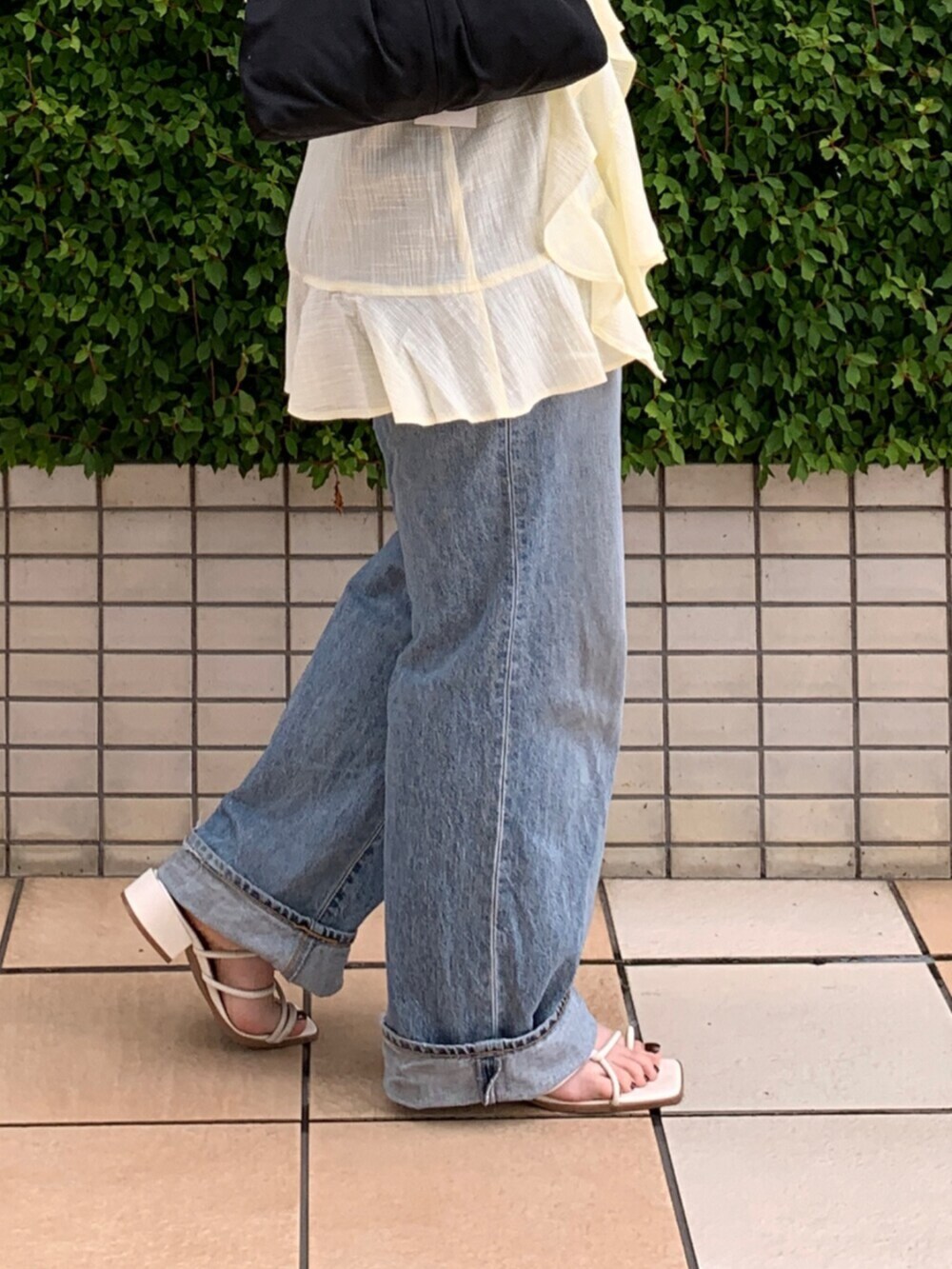 ブルー系のデニムパンツ、イエロー系のキャミソール、ホワイト系のタンクトップを着用したレディースの夏コーディネートの6枚目の写真