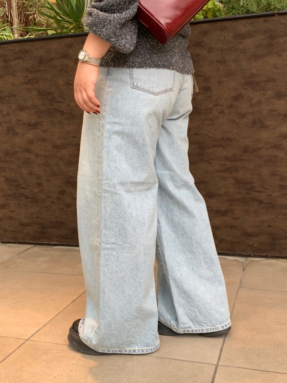 ブラック系のニット/セーター、ブルー系のデニムパンツを着用したレディースの冬コーディネートの5枚目の写真