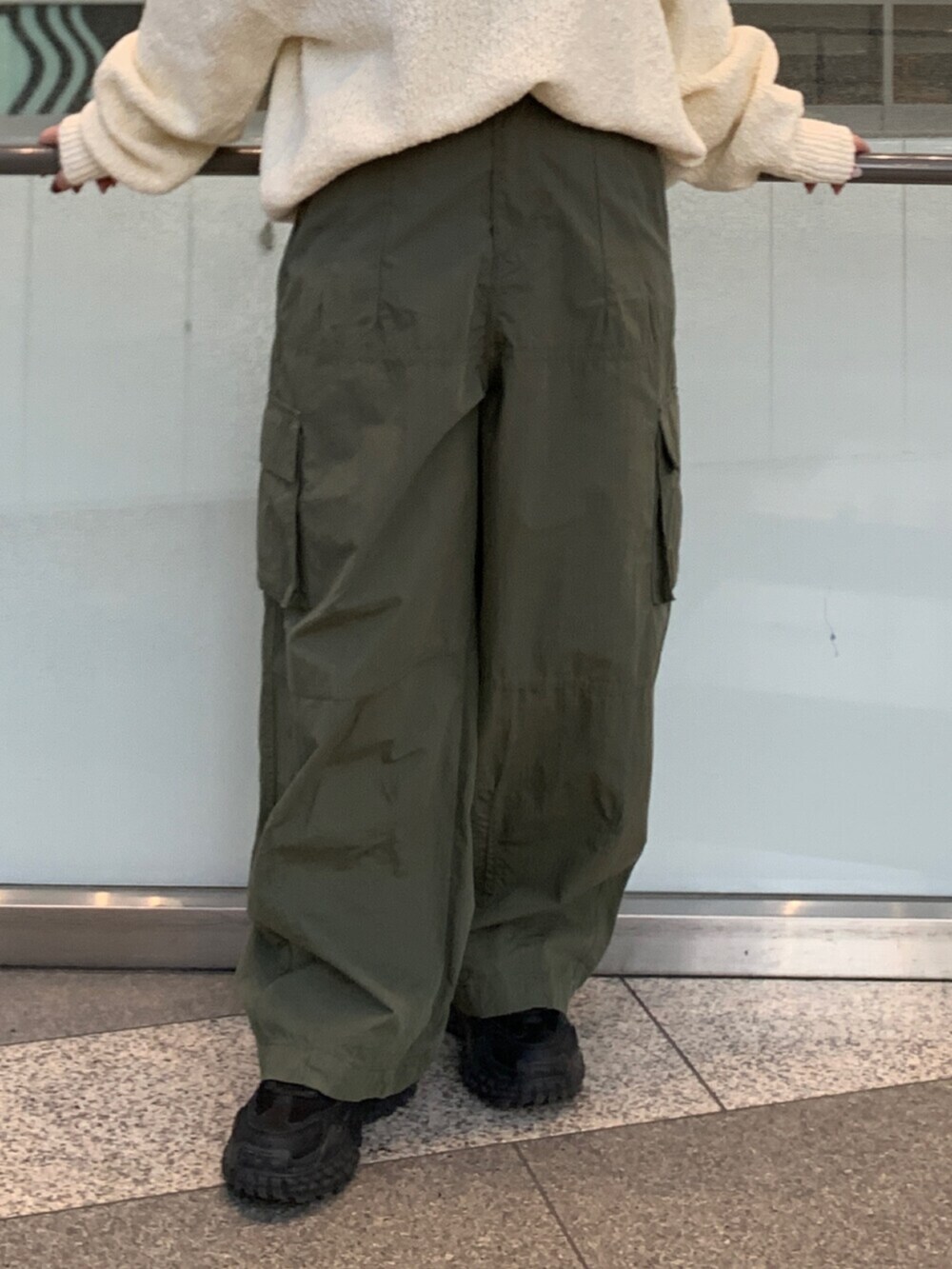 ホワイト系のニット/セーター、グリーン系のその他パンツを着用したレディースの冬コーディネートの5枚目の写真