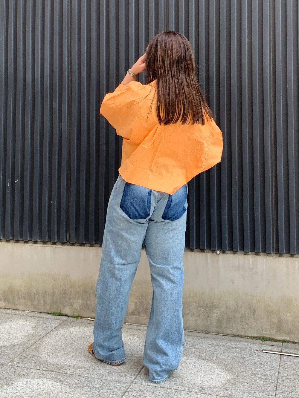 オレンジ系のシャツ/ブラウス、ホワイト系のキャミソール、ブルー系のデニムパンツを着用したレディースの春コーディネートの3枚目の写真