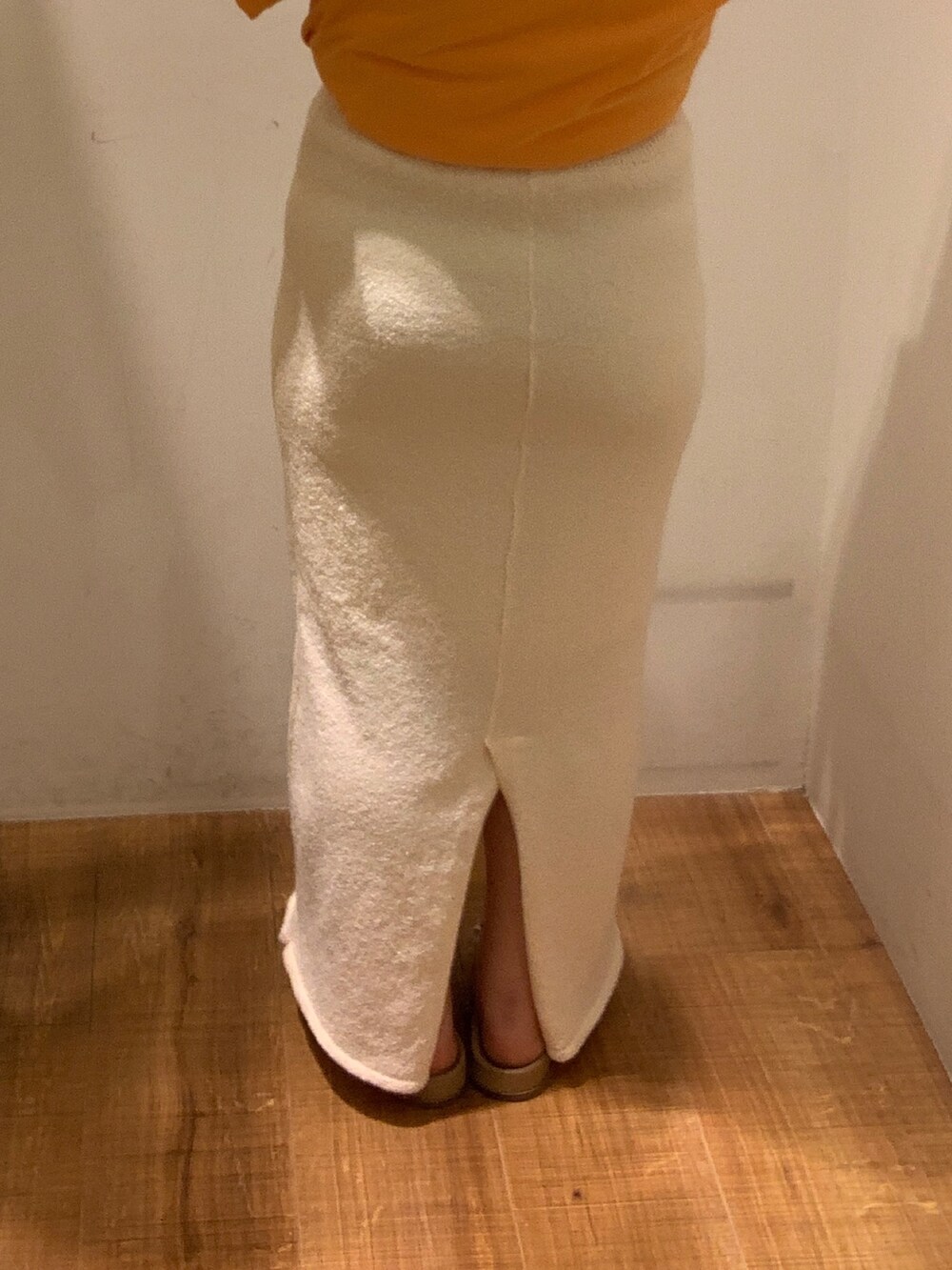 オレンジ系のTシャツ/カットソー、ホワイト系のスカート、ベージュ系のトートバッグを着用したレディースの春コーディネートの7枚目の写真