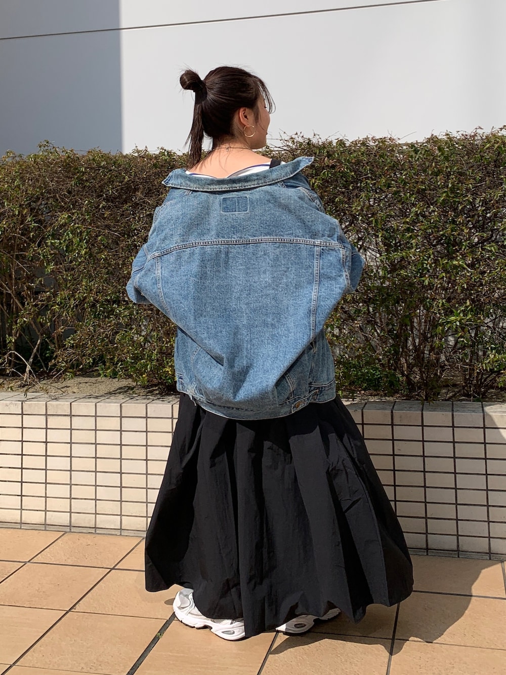 ホワイト系のTシャツ/カットソー、ブルー系のデニムジャケット、ブラック系のワンピースを着用したレディースの春コーディネートの3枚目の写真