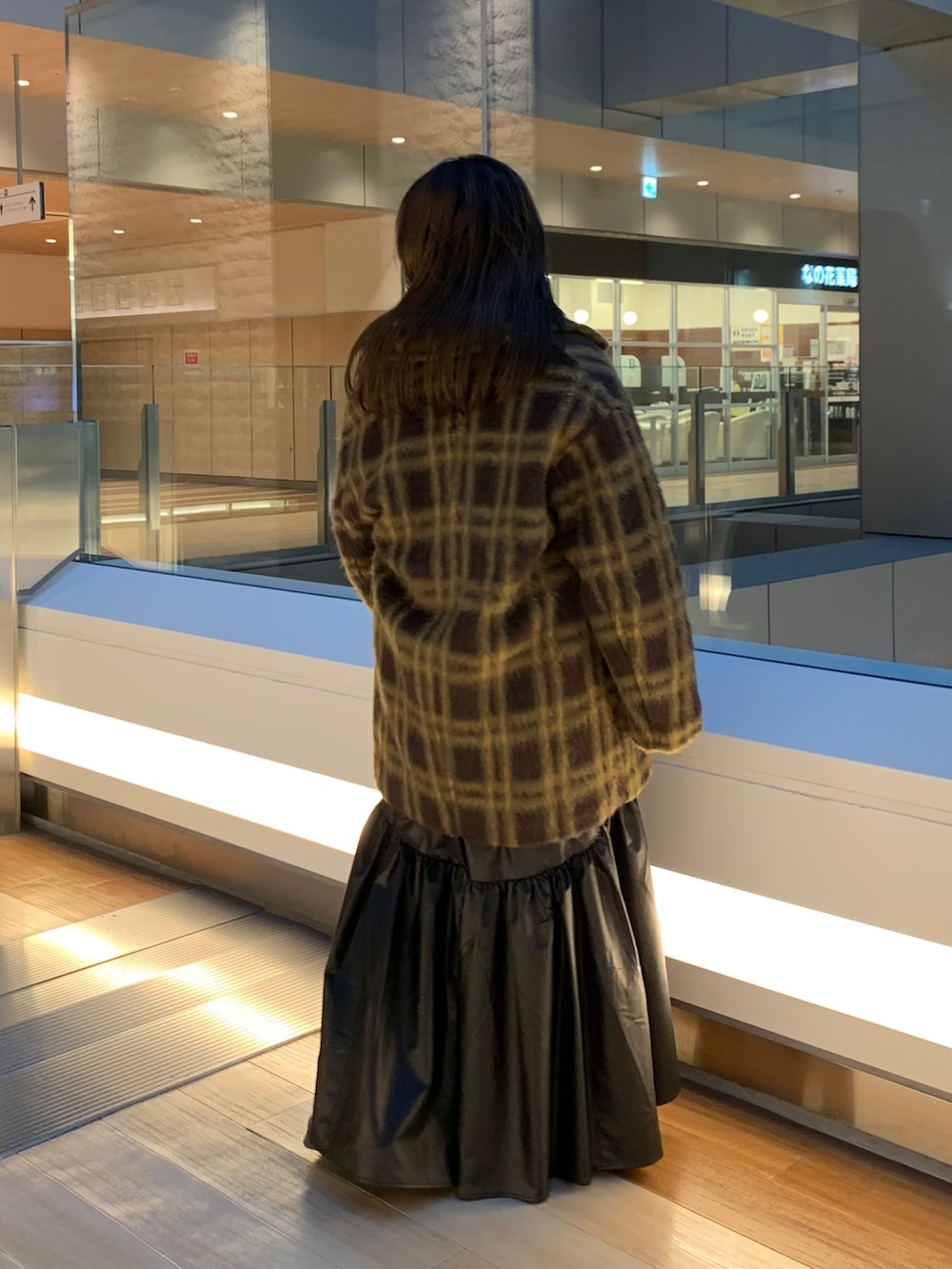 レッド系のニット/セーター、その他のピーコート、ブラック系のスカートを着用したレディースの冬コーディネートの3枚目の写真