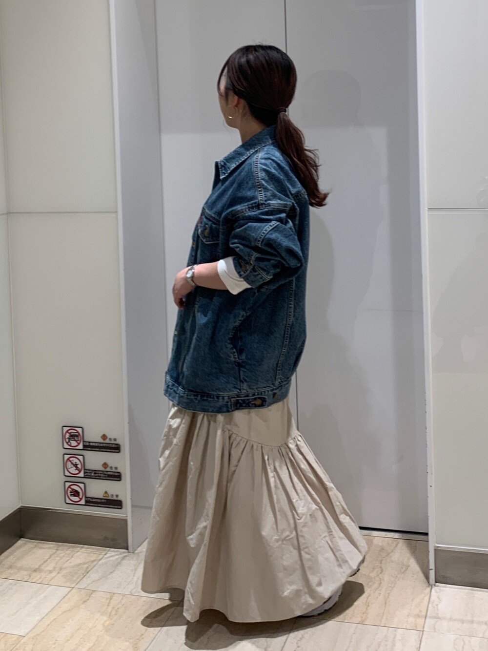 ブルー系のデニムジャケット、ホワイト系のTシャツ/カットソー、ホワイト系のスカートを着用したレディースの冬コーディネートの2枚目の写真