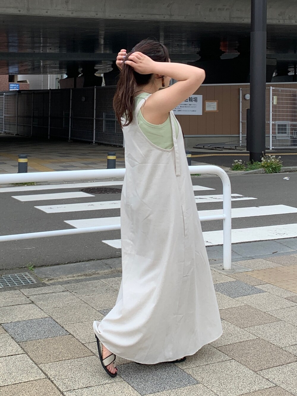 ホワイト系のワンピース、グリーン系のタンクトップを着用したレディースの春コーディネートの2枚目の写真
