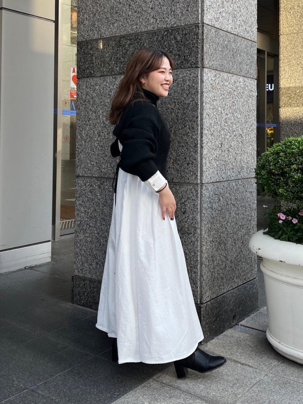 ブラウン系のムートンコート、ブラック系のワンピースを着用したレディースの秋コーディネートの6枚目の写真